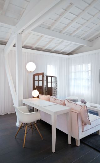Room with white chair and light pink cushions