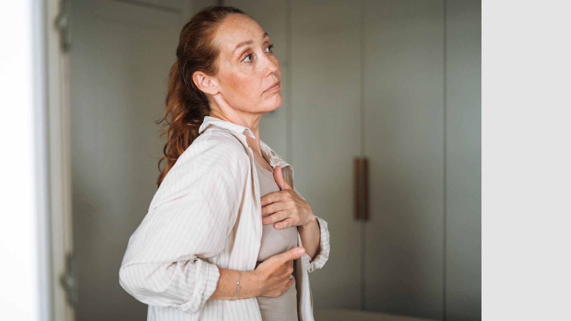Woman examining breast for signs of breast cancer