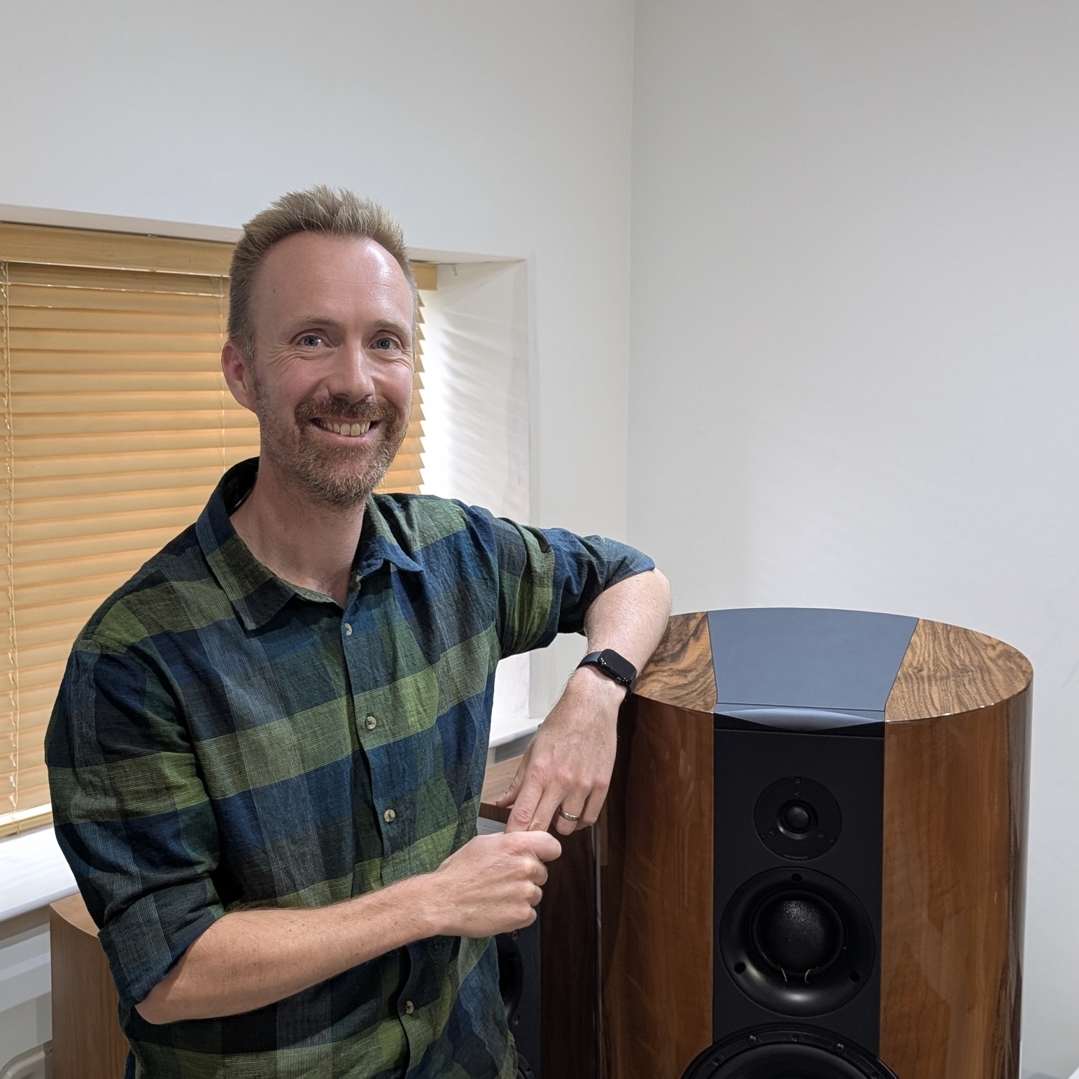 Richard Newman press shot, standing beside a speaker