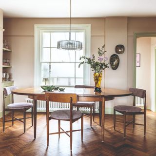 A dining room with hardwood floor and vintage mid-century modern extendable dining table and chairs