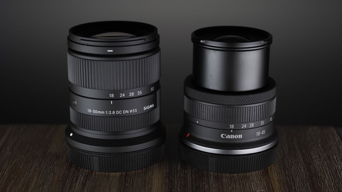 The Sigma 18-50mm f/2.8 DC DN | C Canon RF lens on a wooden surface against a dark background with moody lighting
