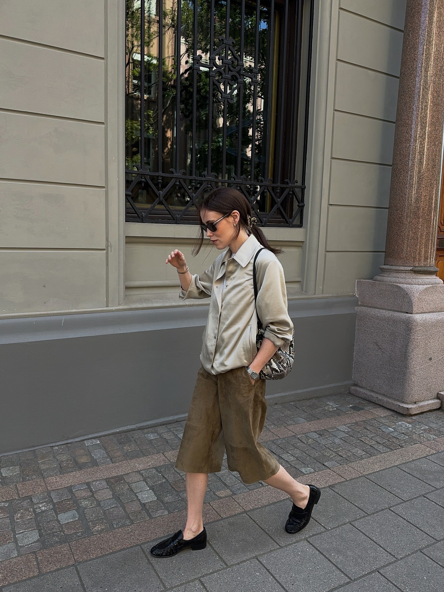 A woman wearing a silky shirt with an effortlessly undone ponytail
