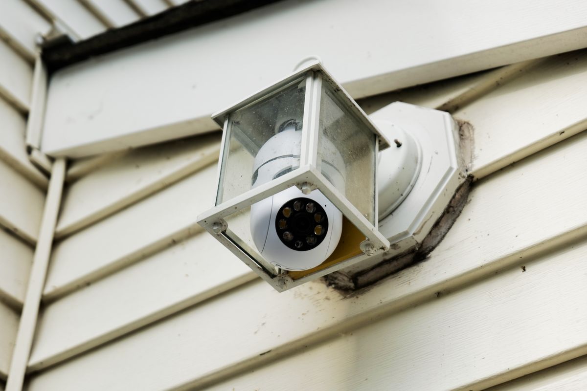 Symynelec security camera light bulb installed outdoors inside of light fixture.