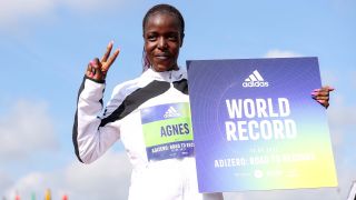 Kenyan Agnes Jebet Tirop posing with a sign that says "World Record" at the ADIDAS ADIZERO: ROAD TO RECORDS event in Germany