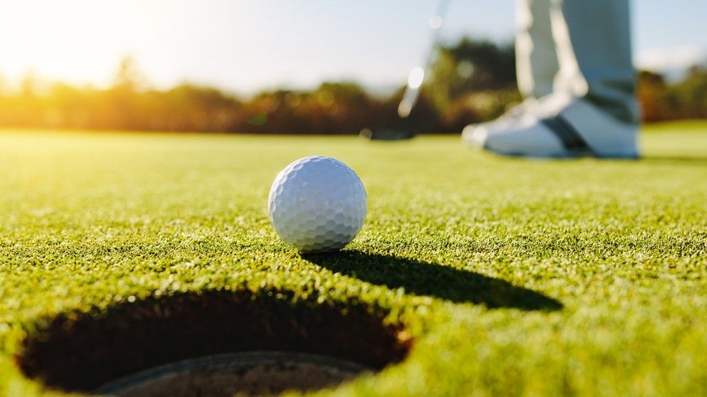 a photo of a man putting on the golf green