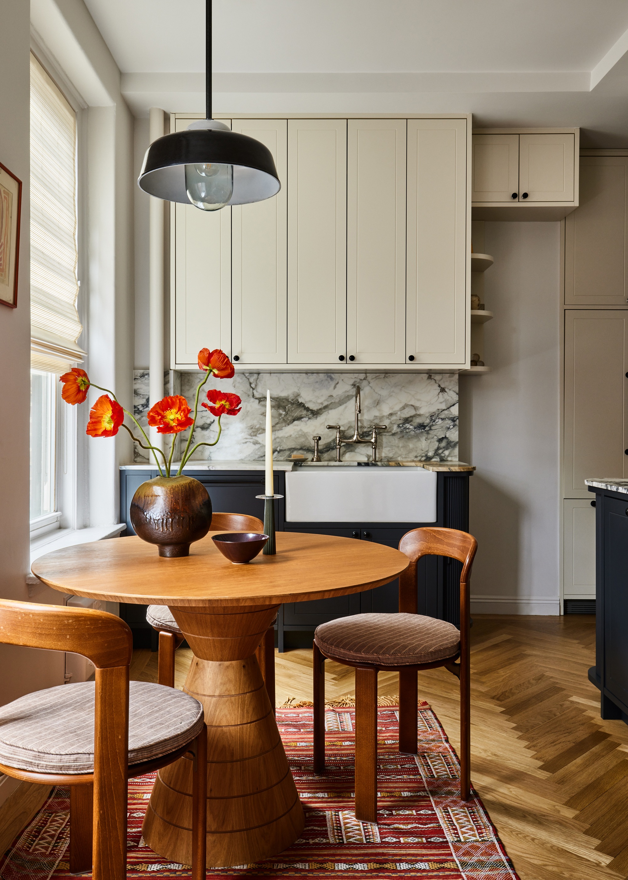 a cream gray and marble kitchen with a wood dining table and chairs