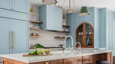 a light blue kitchen with a wooden arch coffee cabinet