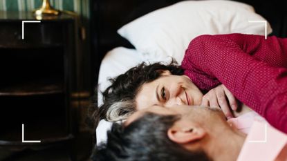 Man and woman in bed together, looking into each other&#039;s eyes after reading principles of tantric sex