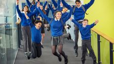 Happy children jumping wearing school uniform
