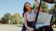 Katie Clarke sitting on a golf cart