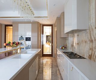 white and gold kitchen with modern chandelier