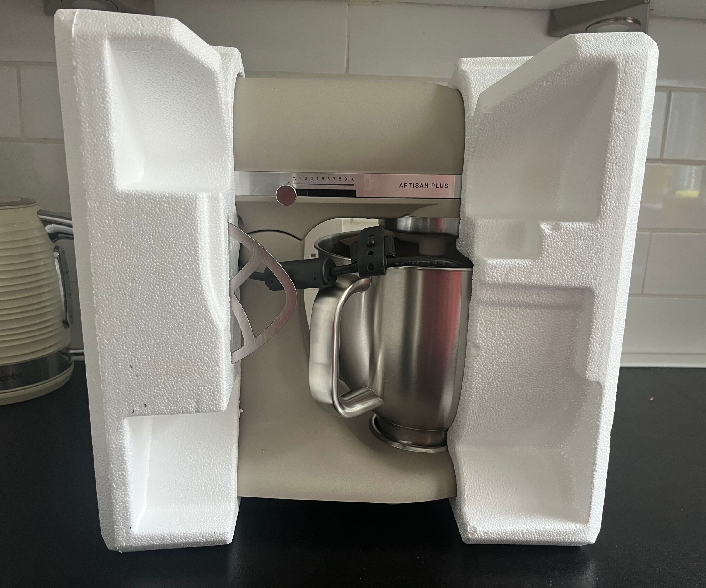 The Oat colored KitchenAid Artisan Plus Stand Mixer in the styrofoam packadging