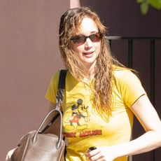 Jennifer Lawrence outside wearing a yellow T-shirt and red track pants 