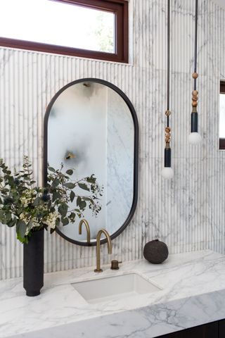 A bathroom with pendant lights next to the mirror