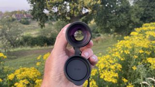 A hand holding a Opticron Explorer WA ED-R 8x42 monocular