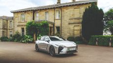 Lexus ES in front of a sand-coloured old house
