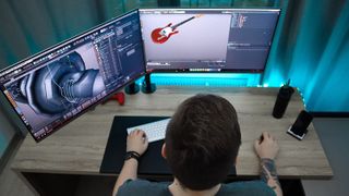 A person using dual monitors for a digital design project.