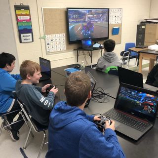 Boys use laptop computers to play esports games in a classroom