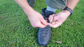 how to break in hiking boots: man tying hiking boots