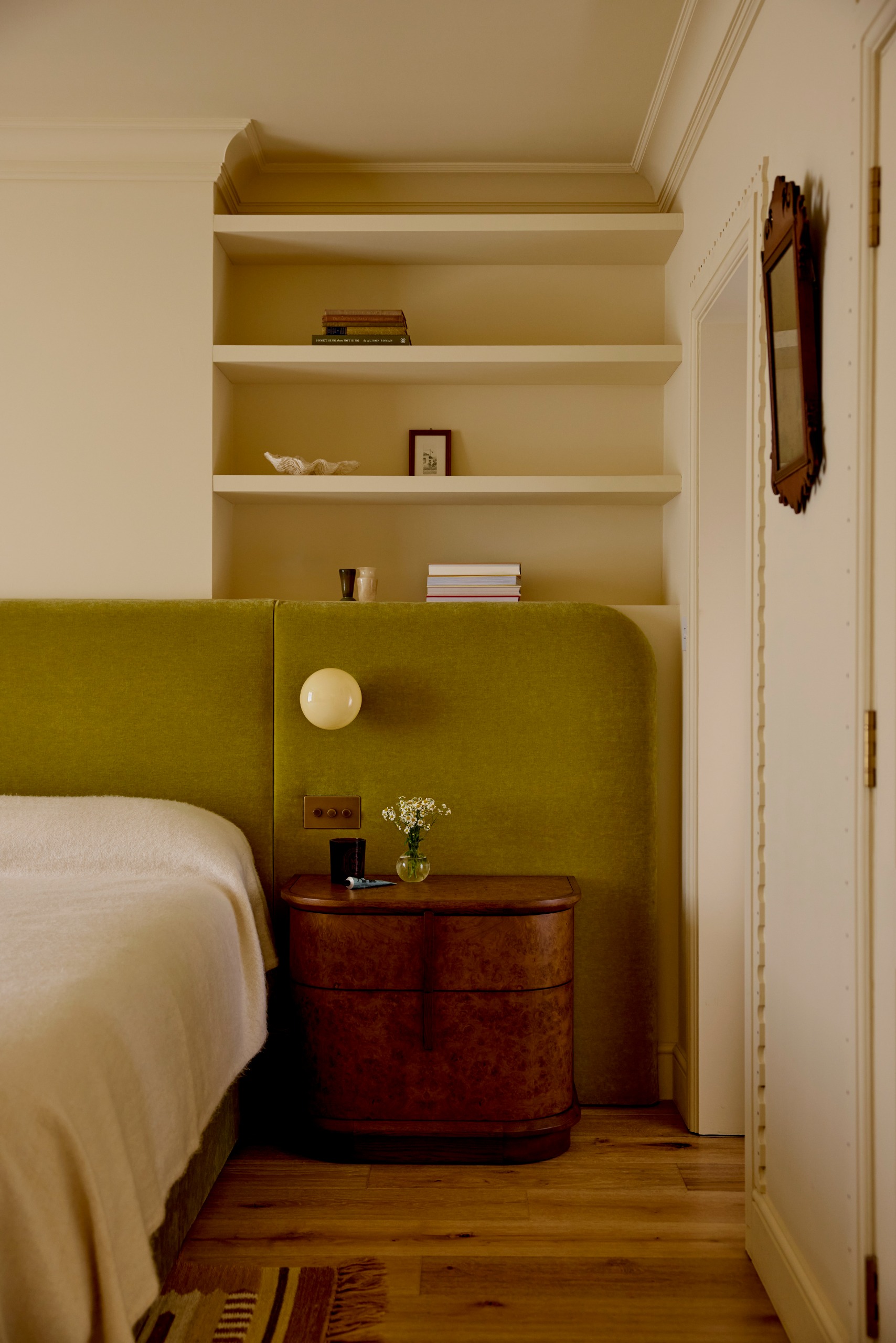 London modern bedroom with large fabric headboard and alcove shelving
