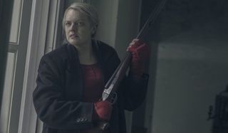 The Handmaid's Tale Elizabeth Moss holding a shotgun with a stressed look