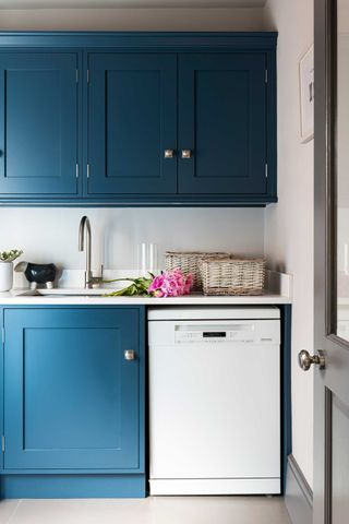 a laundry room with blue cabinets