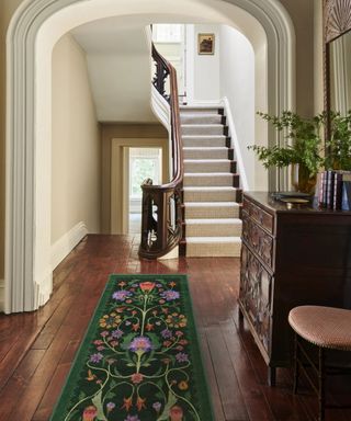 entryway with colorful rug and wooden furniture and flooring