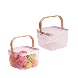 Two pink baskets with wooden handles, with one containing apples