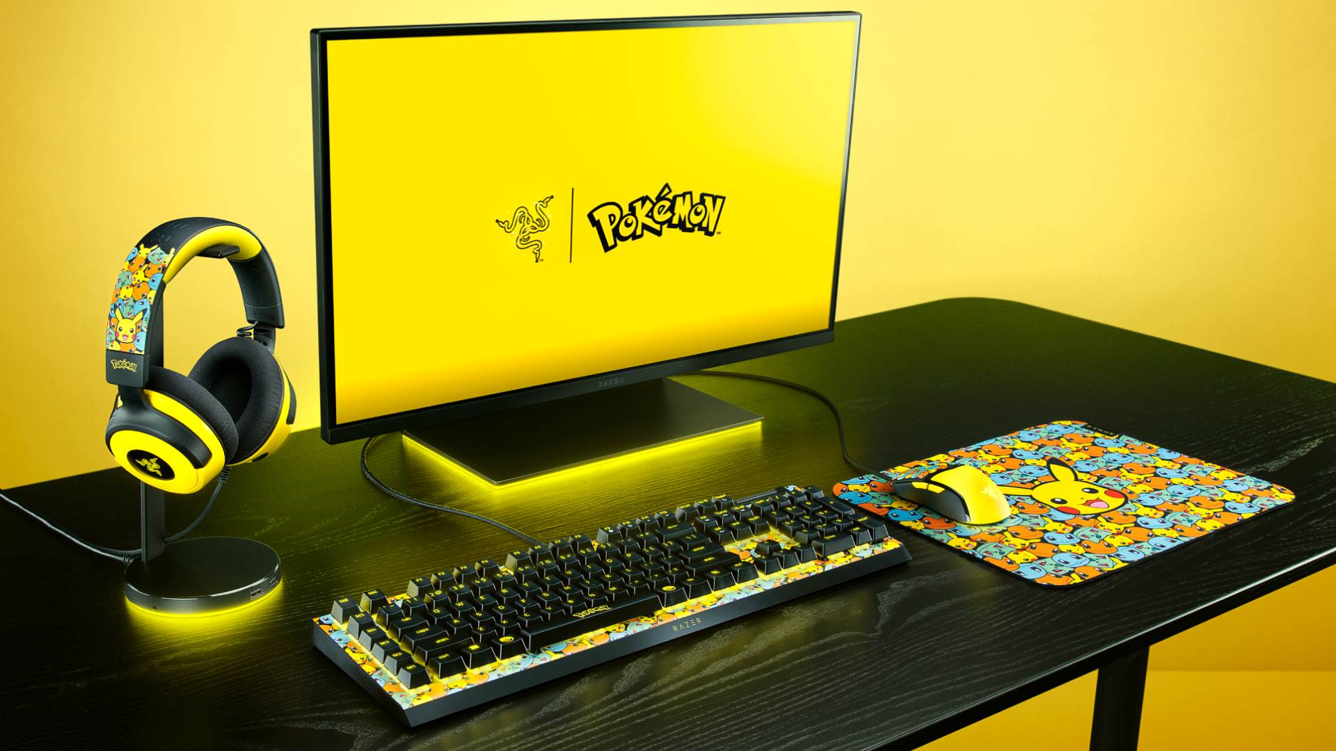 Promo image of the Razer Pokemon Collection sitting on a black desk, with a matching yellow background behind it.
