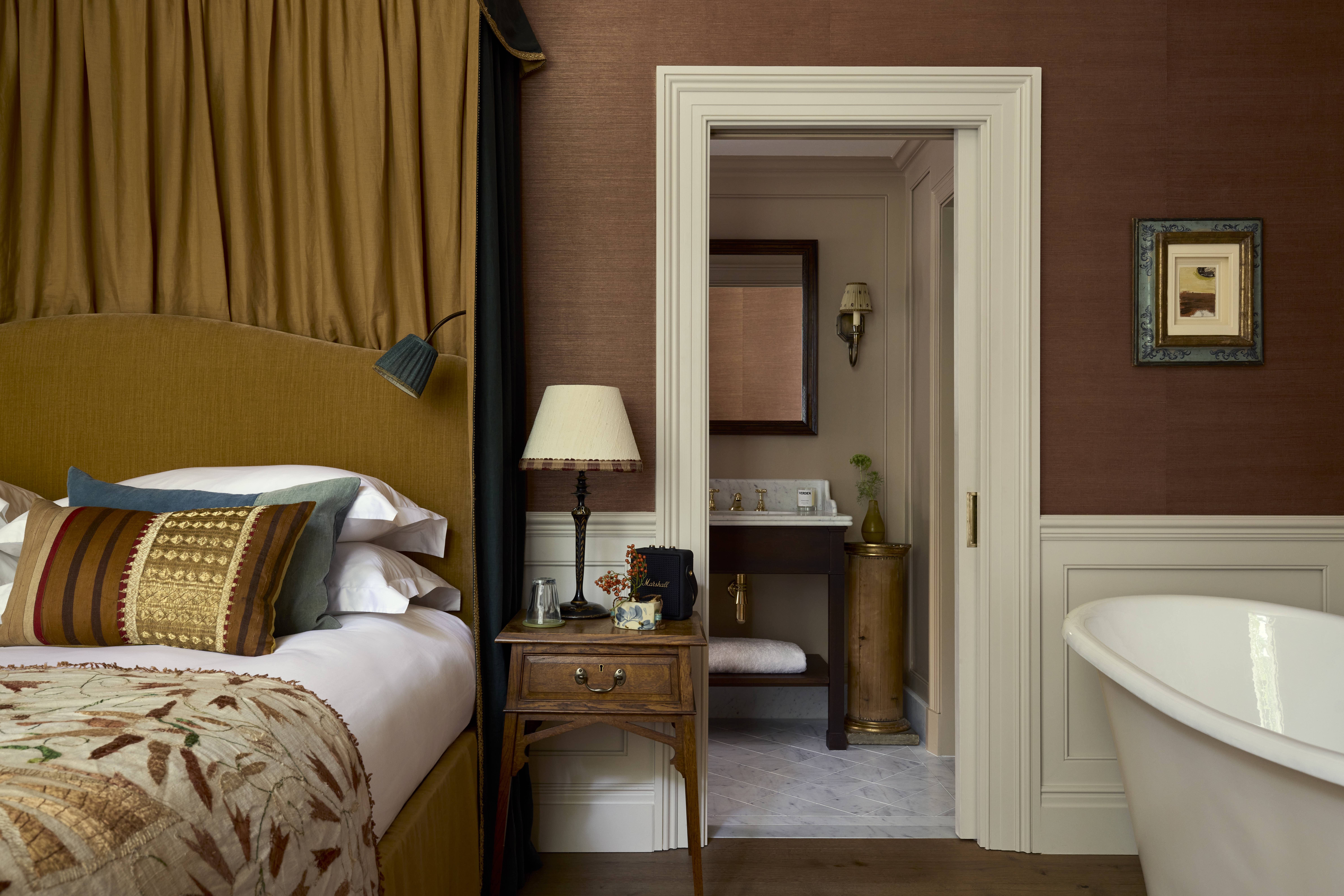 A bedroom at the Zetter Bloomsbury with free standing bath in the corner 