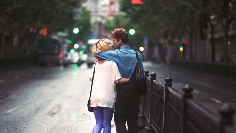 Man and woman walking and kissing