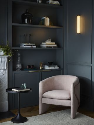 dark painted living room wall panelling with armchairs and modern light