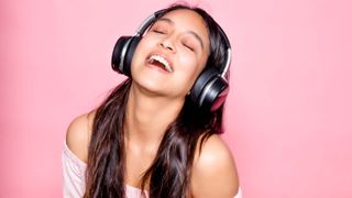 Sonic Lamb headphones worn by a woman on pink background