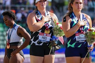 Gwen Berry (L), third place, turns away from U.S. flag during the U.S. National Anthem as DeAnna Price (C), first place, and Brooke Andersen, second place, also stand on the podium after the Women's Hammer Throw final