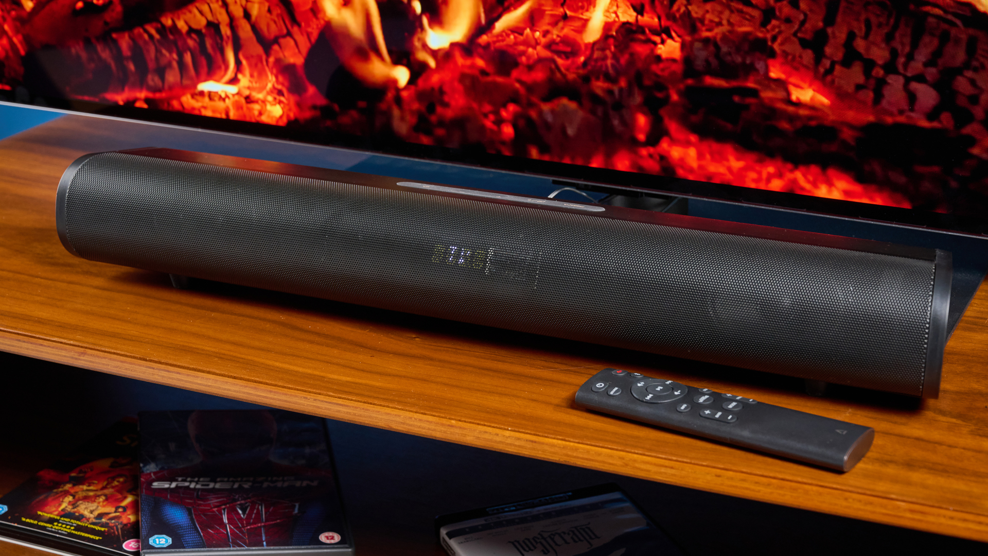 the creative stage pro soundbar and subwoofer, a super-budget home cinema system with 2.1 channels and a remote control photographed on a wooden tv stand with a TV behind