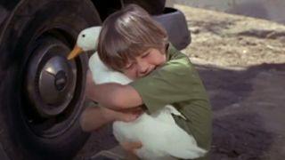 boy hugging a duck