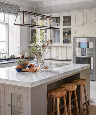 cream kitchen with marble island and wooden seating
