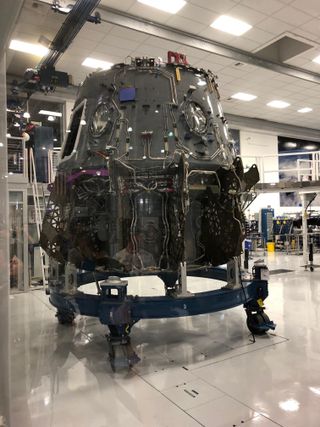 The Crew Dragon capsule that will make the vehicle’s first crewed flight — currently scheduled for April 2019 — under construction in a clean room at SpaceX headquarters.