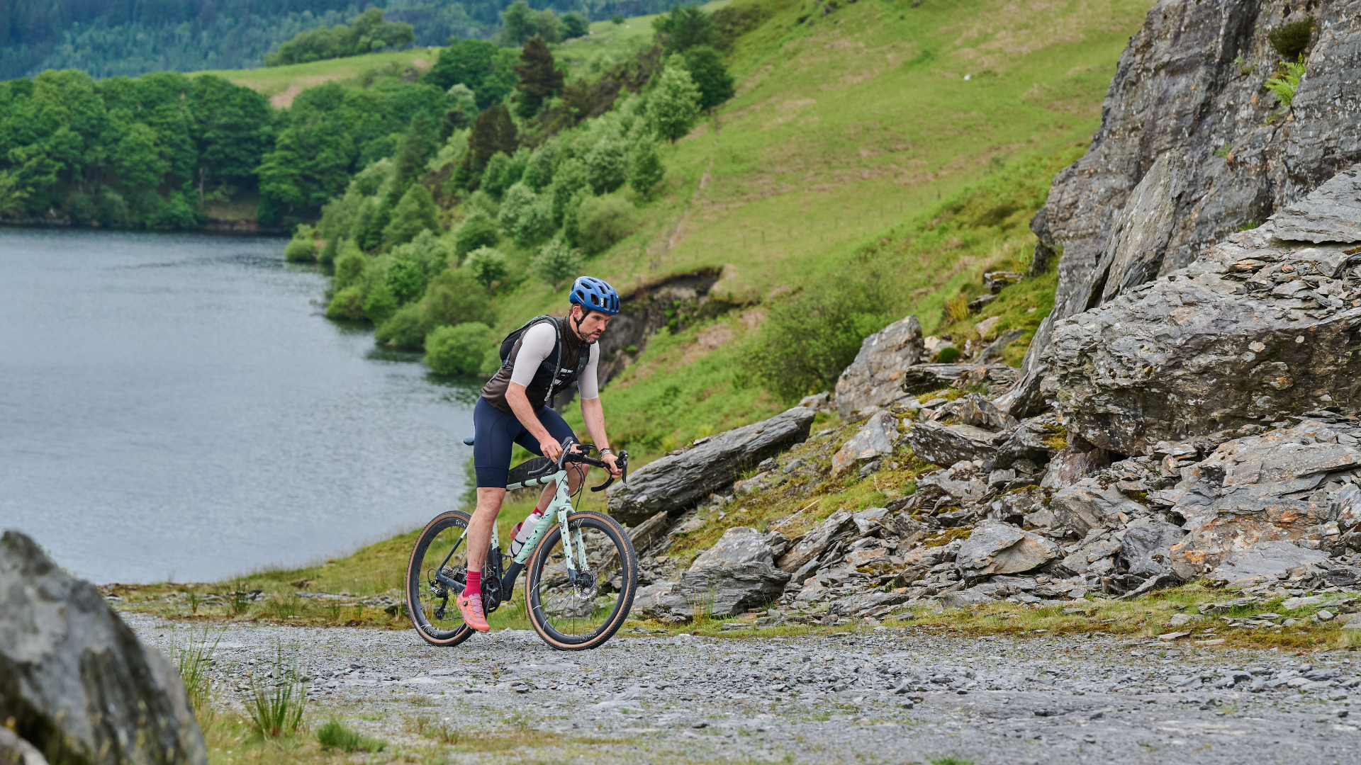 A cyclist navigates a rocky gravel trail in the UK