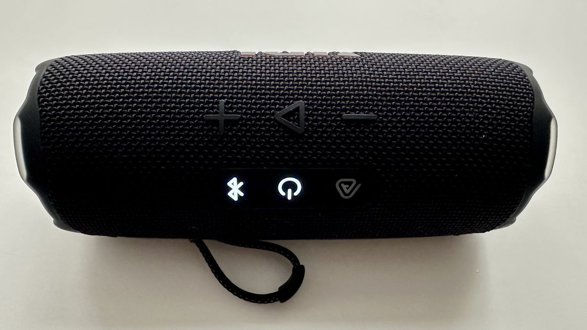 JBL Flip 7 portable Bluetooth speaker, with Power and Bluetooth lights on, on white surface