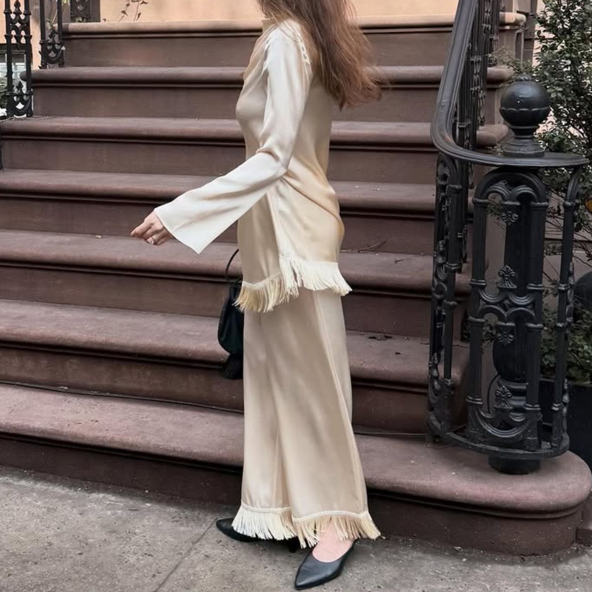 An image of @kathleenfialka wearing tassel trousers, one of the biggest transitional trouser trends of 2026. 