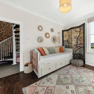 White spare bedroom with white sofa bed and patterned rug