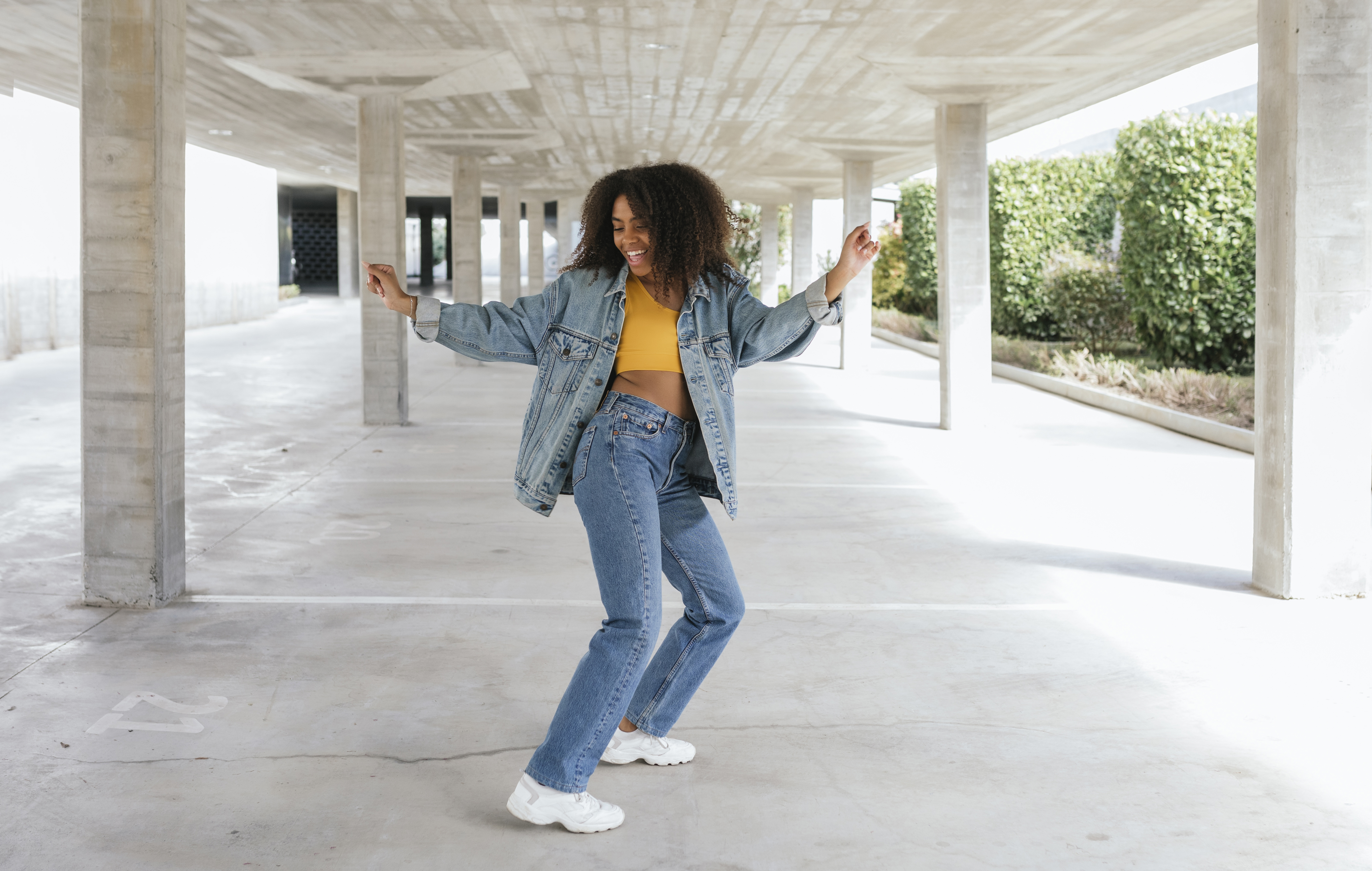 Is vaginal discharge normal? Smiling woman dancing in an empty parking