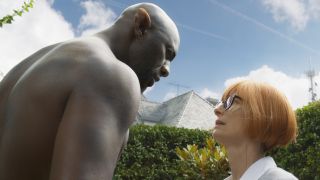 Idris Elba and Tilda Swinton looking at each other in a beautiful garden in Three Thousand Years of Longing.