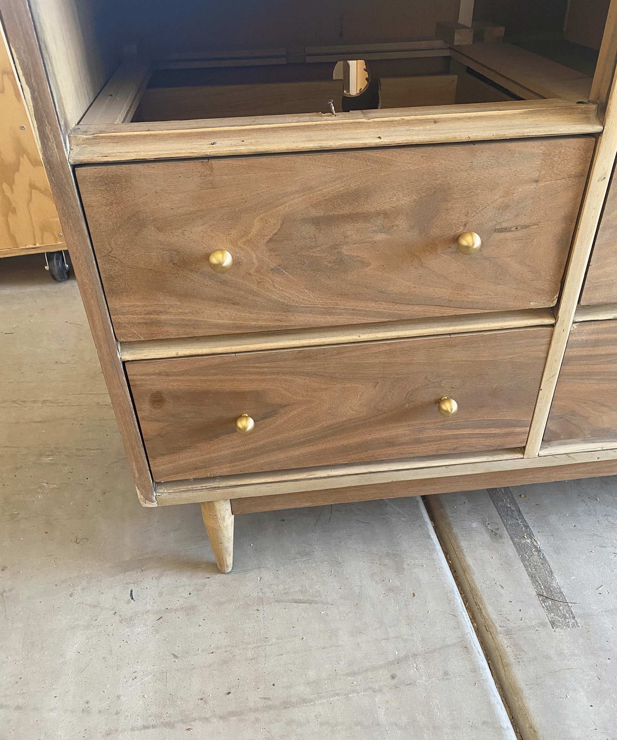 Close up of wooden dresser vanity with brass knob handle decor
