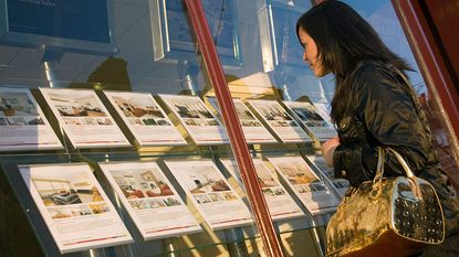 Woman looking in an estate agent's window