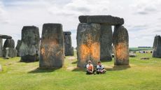 Protesters sit after spray painting the Stonehenge monument in England