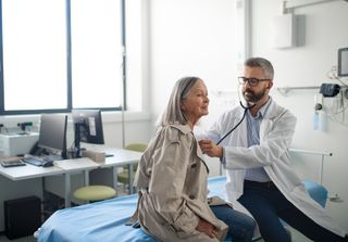 Older woman gets heart checked by doctor.