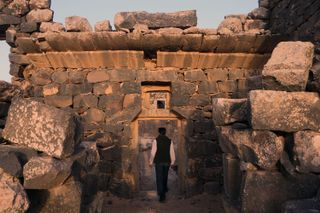 A man walks at sunset through the ruins of Umm Al-Jimal in Jordan