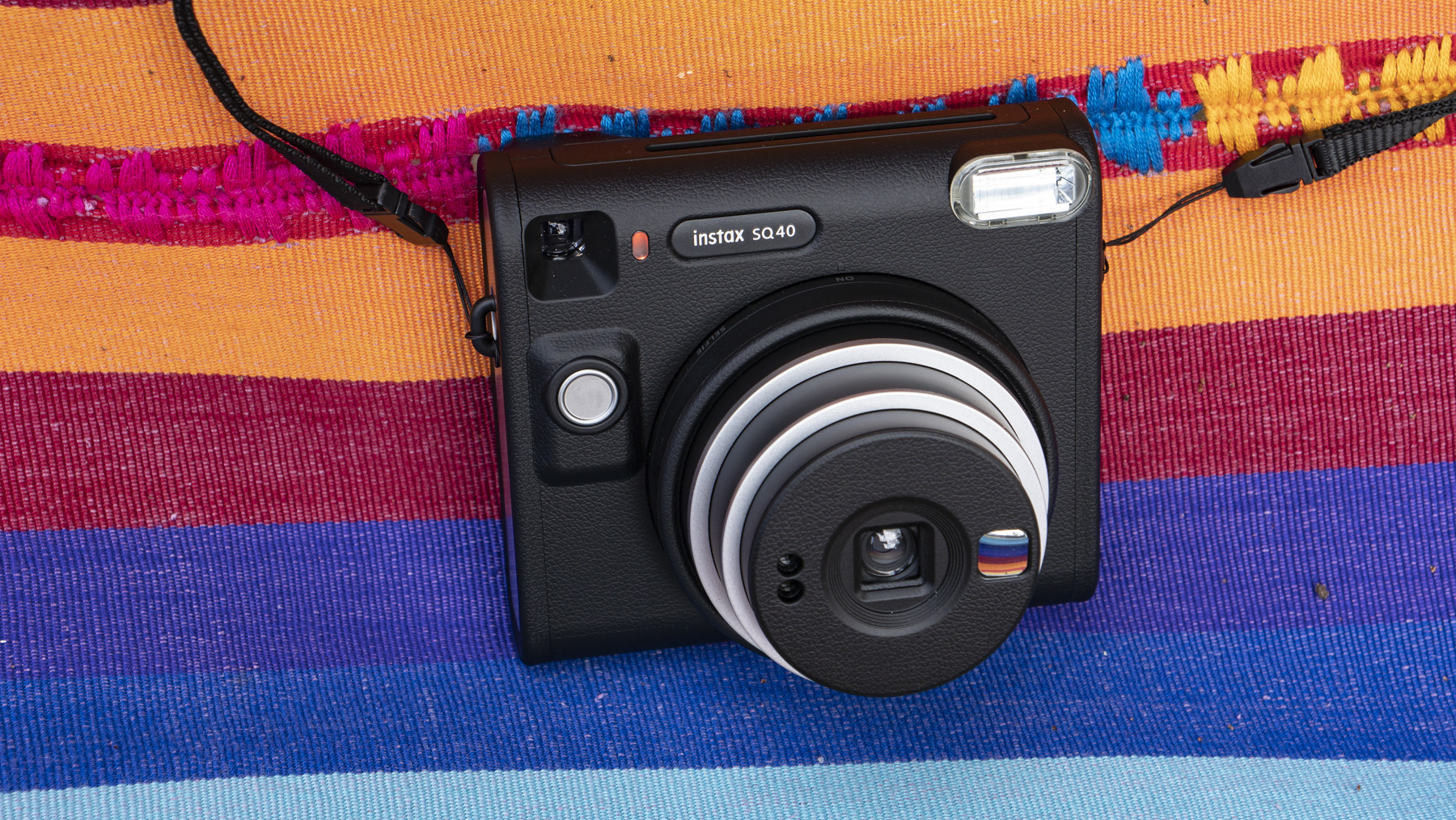 Fujifilm Instax SQ40 camera on a multi-color fabric background